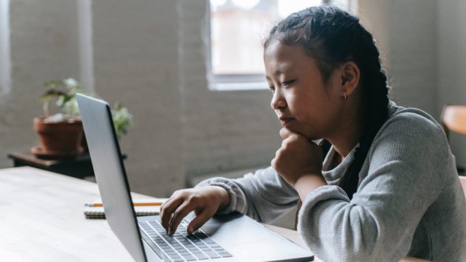 teen girl studying on a laptop